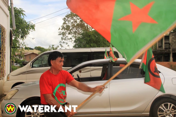 Man in Suriname zwaait dagelijks drie keren een uur lang met vlag als protest
