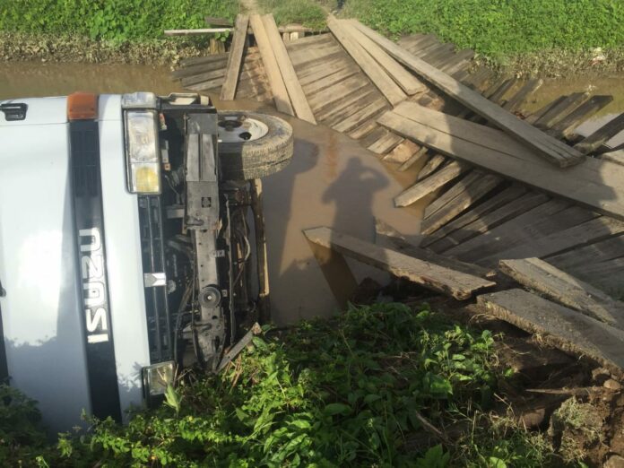 Truck valt in het water door kapotte brug in Suriname