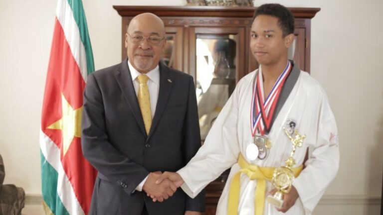 President Bouterse ontvangt 16-jarige winnaar gouden medaille