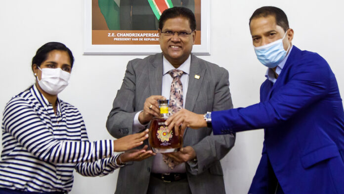 President Santokhi neemt eerste Borgoe Srefidensi Edition fles in ontvangst