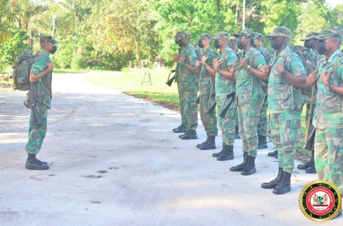 Cursisten Surinaamse Militaire School op voetpatrouille in dorp Hollandse kamp