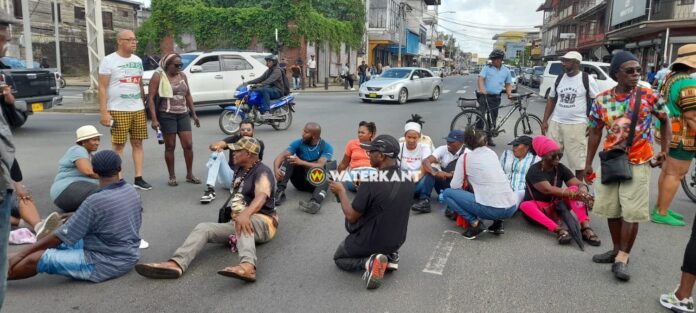 Demonstranten blokkeren verkeer door op de weg te gaan zitten